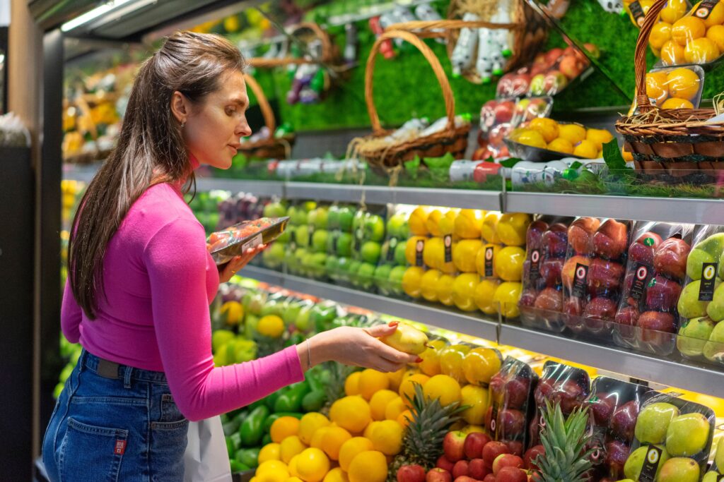 Persona eligiendo frutas y verduras frescas en el supermercado