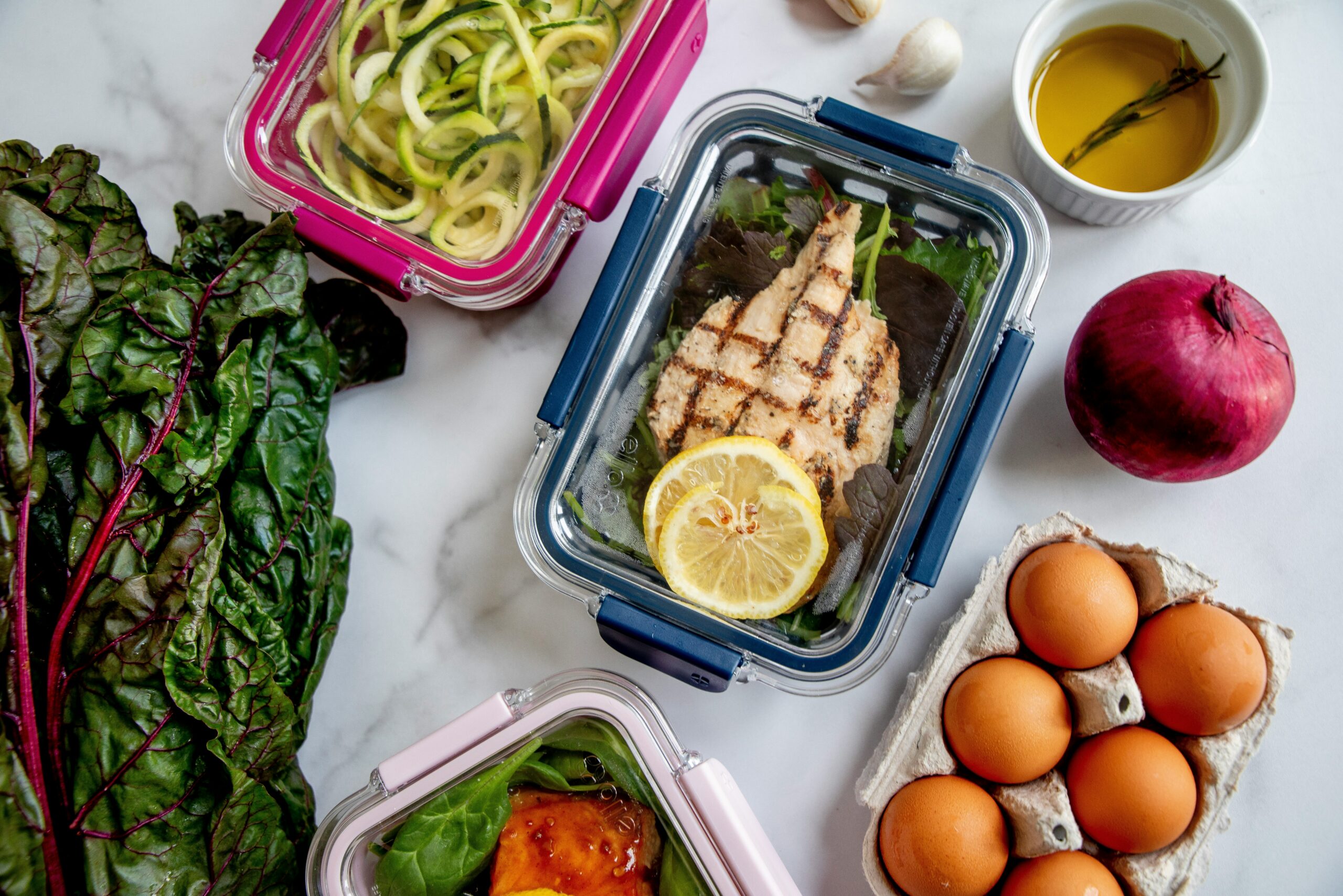 Meal prep saludable con recipientes de comida preparada y alimentos frescos